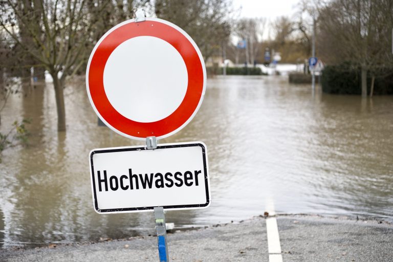 Hochwasser; im Vordergrund Schild "Hochwasser"