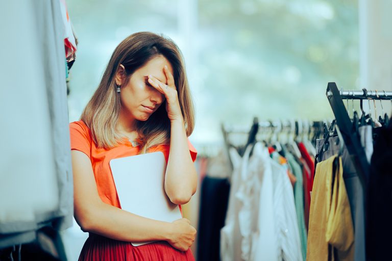 Unglücklicher Filialleiter hält ein PC-Tablet in der Hand und fühlt sich deprimiert